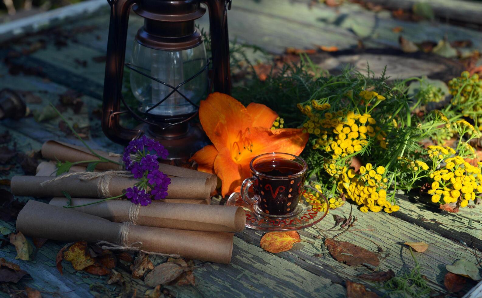 Mystic still life with old paper scrolls, lantern, flowers and witchy ritual objects on old table. Occult, esoteric, wicca and divination concept. photo