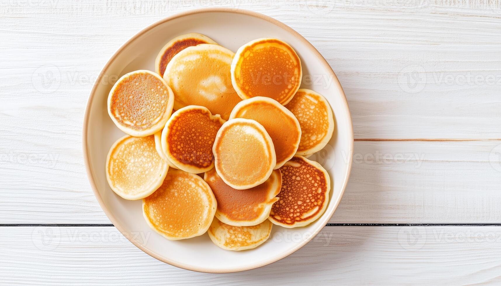 Mini pancakes simple food for breakfast on white plate, flat lay white background photo