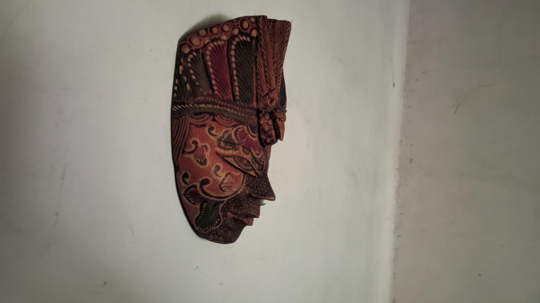 a decorative mask hanging on the wall photo