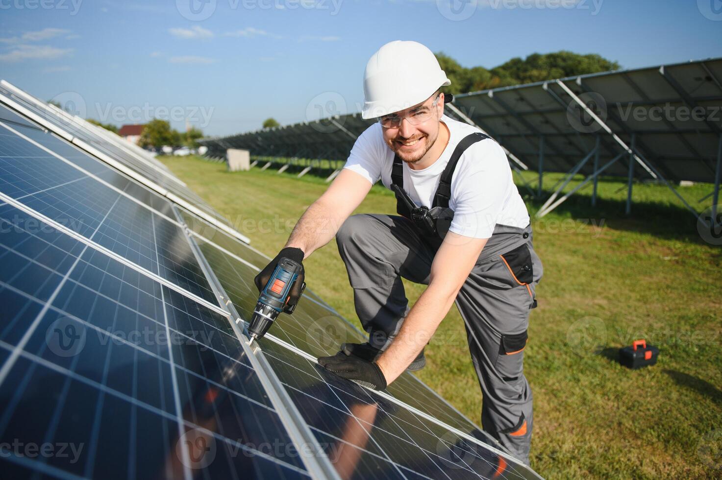 Man technician mounting photovoltaic solar moduls. Engineer in helmet installing solar panel system outdoors photo