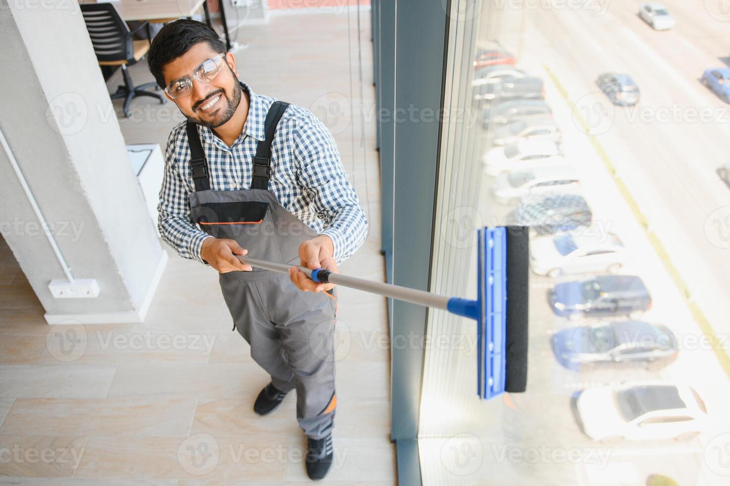Cheerful male person cleaning window photo