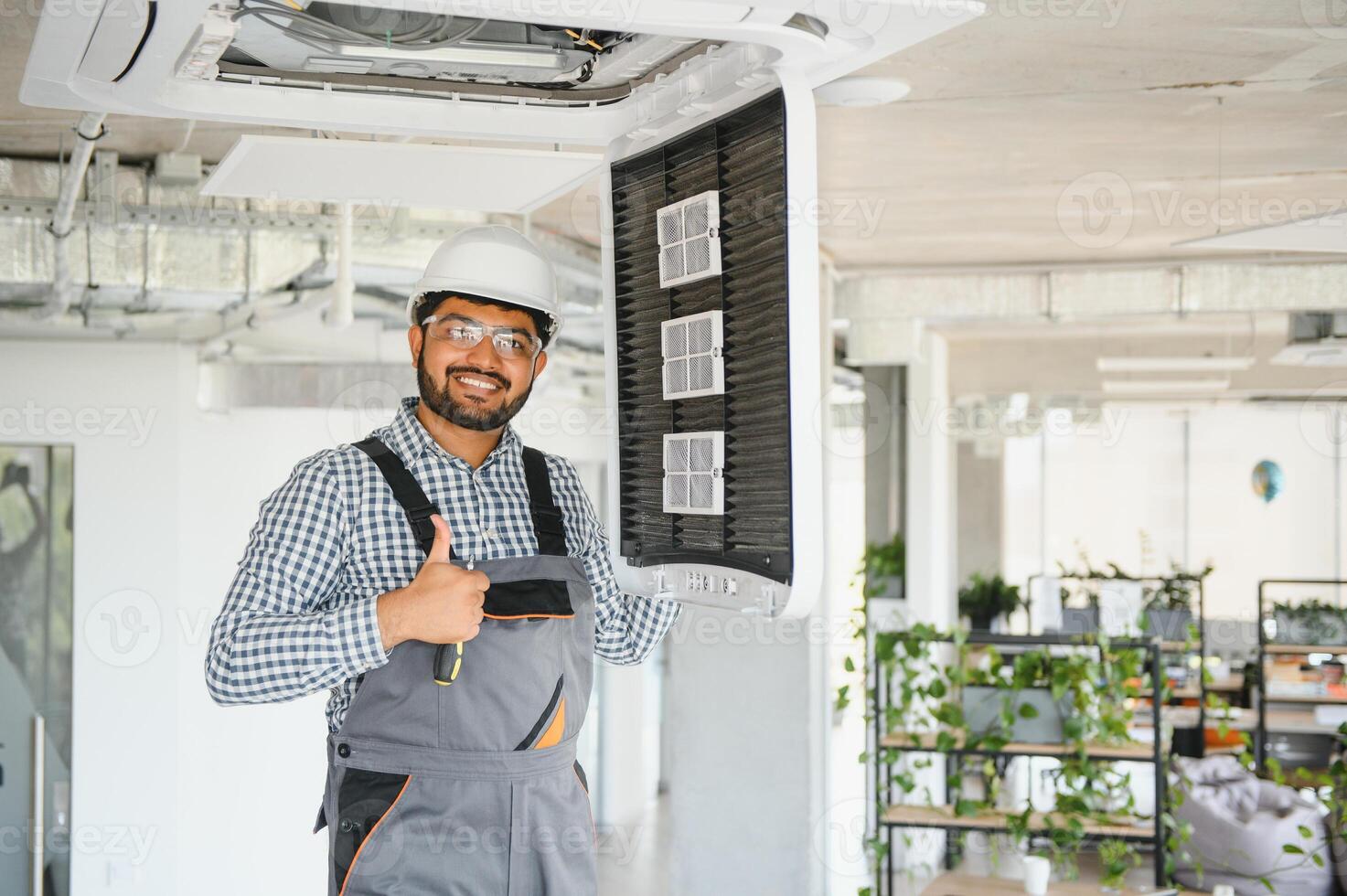 Professional technician maintaining modern air conditioner indoors. Space for text photo
