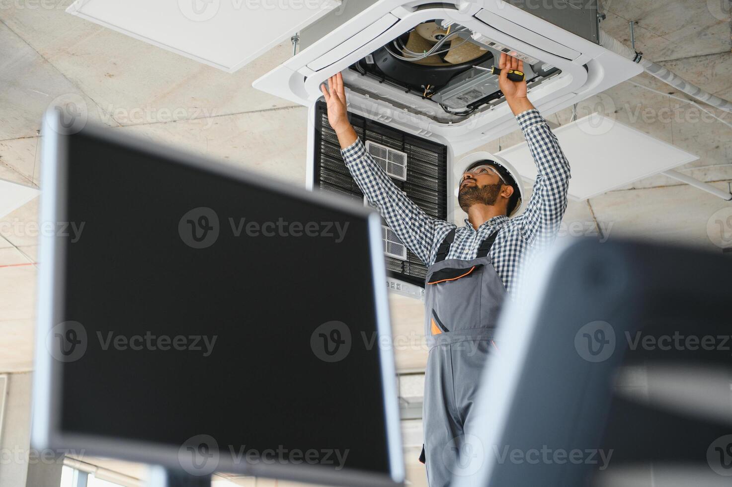 Professional technician maintaining modern air conditioner indoors. Space for text photo