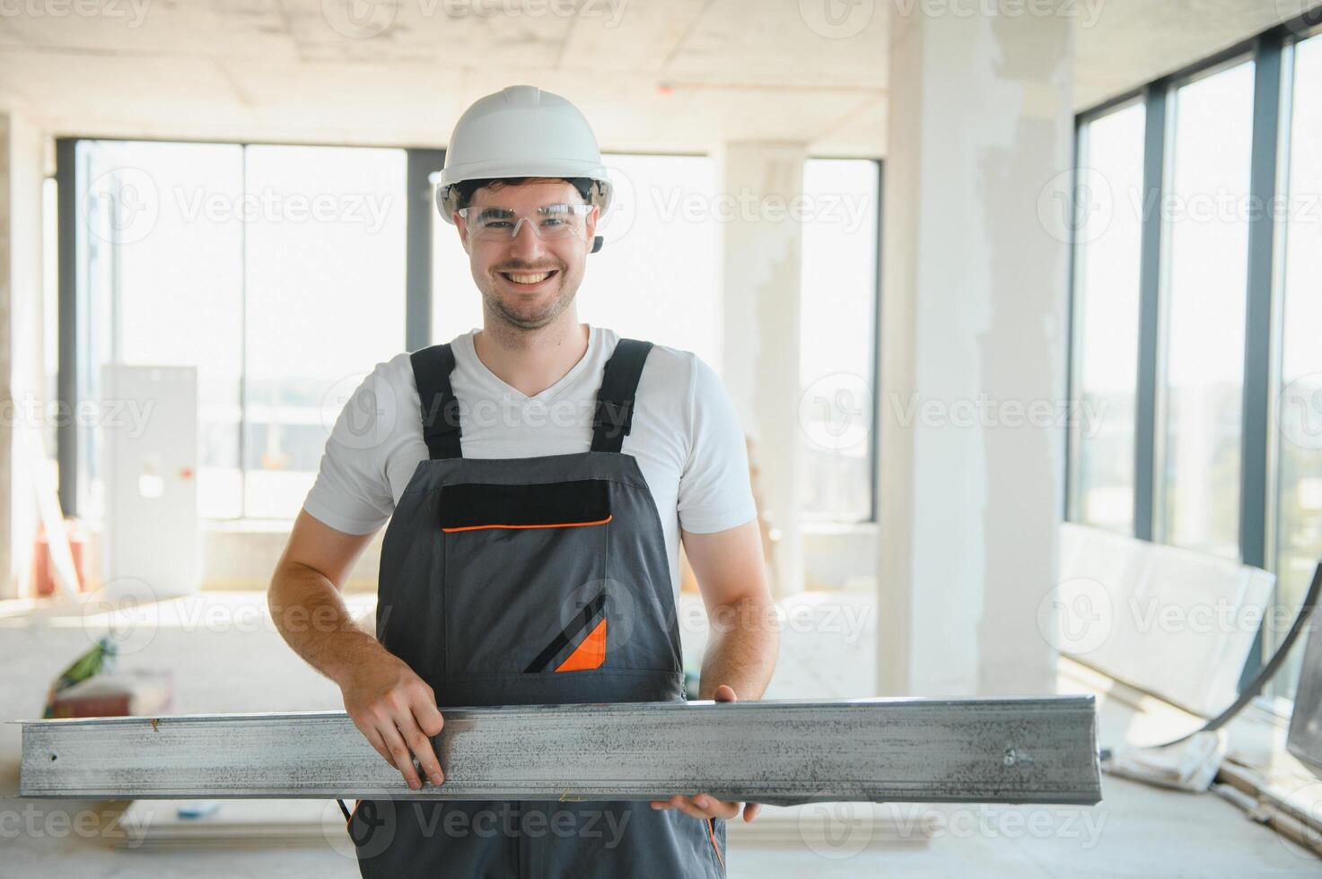 Builder in working uniform cutting metal profile with cutting machine at the construction site indoors photo
