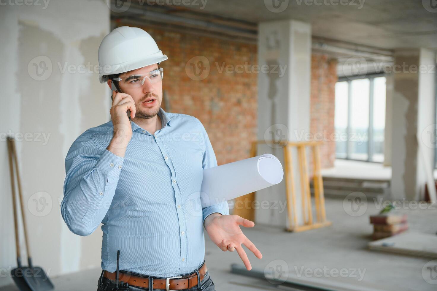 Architect holding blueprints and wearing a helmet photo