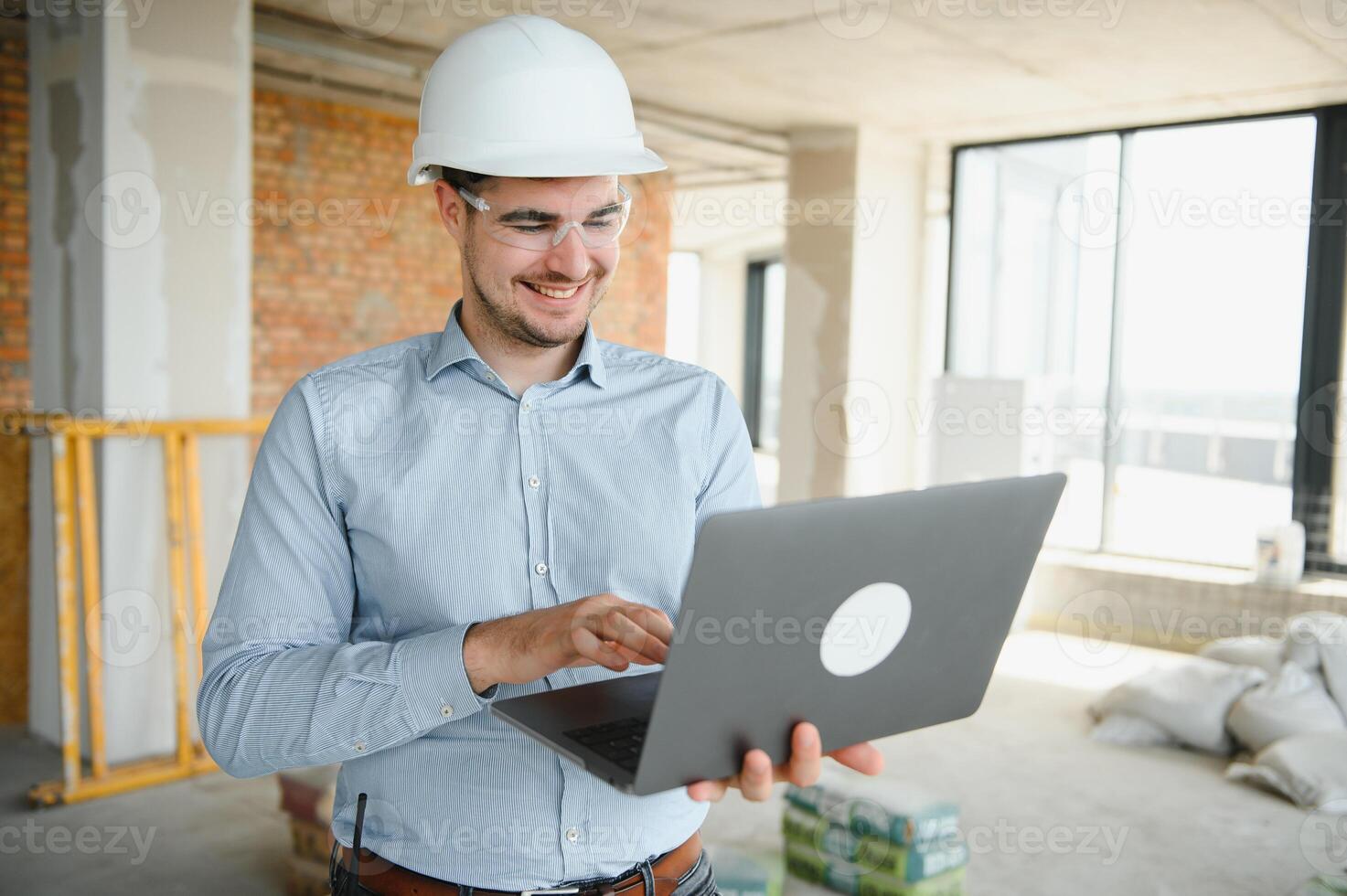 Supervisor using laptop at construction site photo