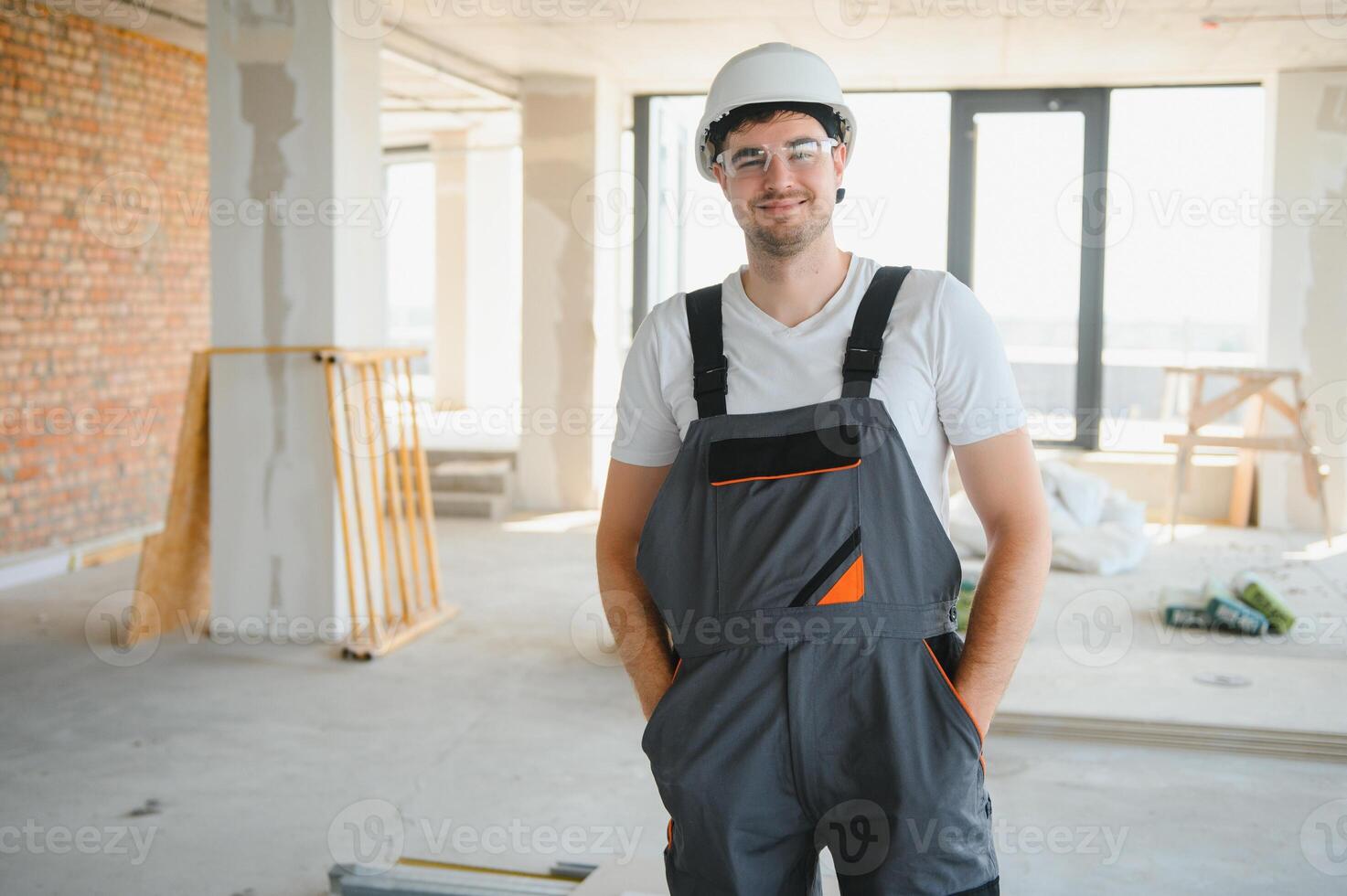 Portrait of a builder in the process of working on a construction site indoors photo