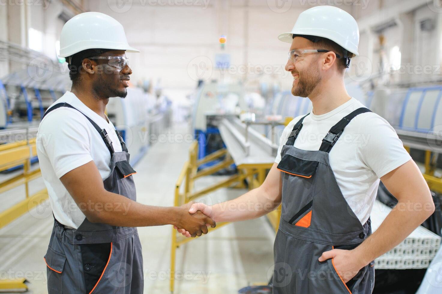Two workers in production plant as team discussing, industrial scene in background photo