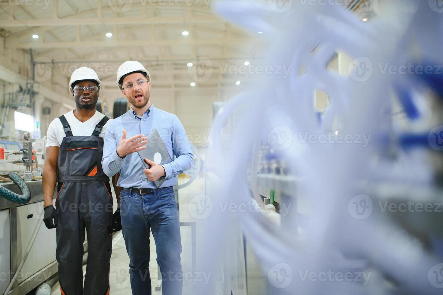 Two workers at a factory for the production of plastic windows. Engineer and worker on the production line photo