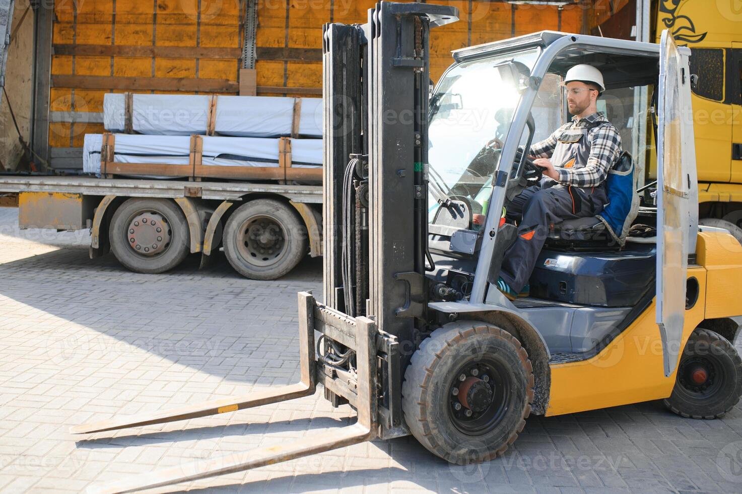 Portrait of professional forklift driver in factory's warehouse photo