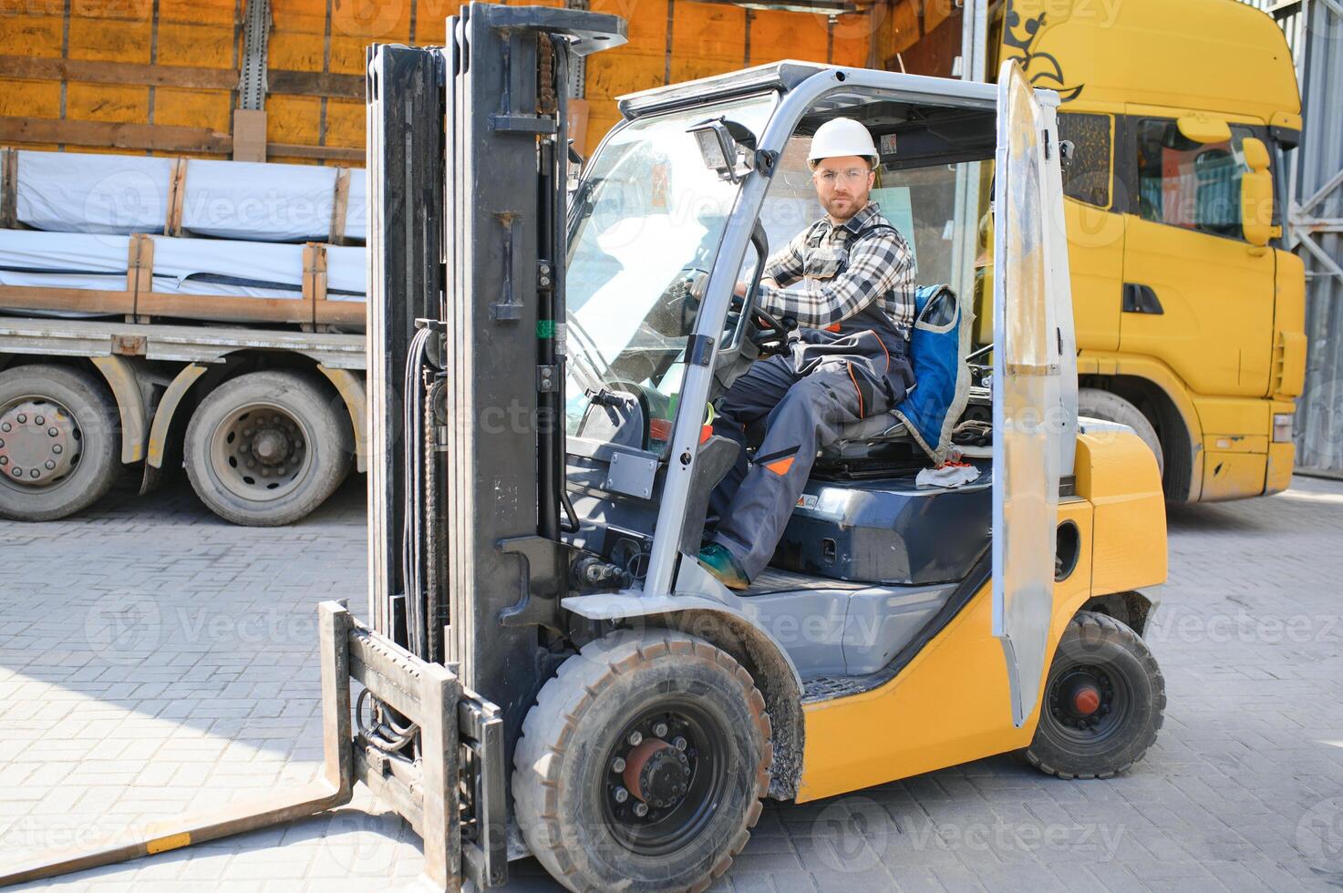 Man worker at forklift driver happy working in industry factory logistic ship photo