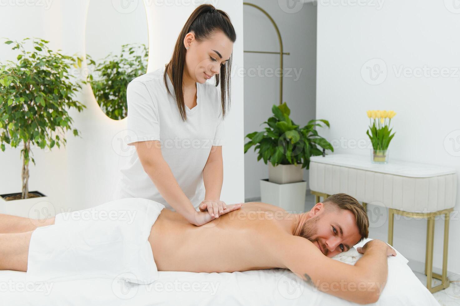 Young man is enjoying massage on spa treatment photo