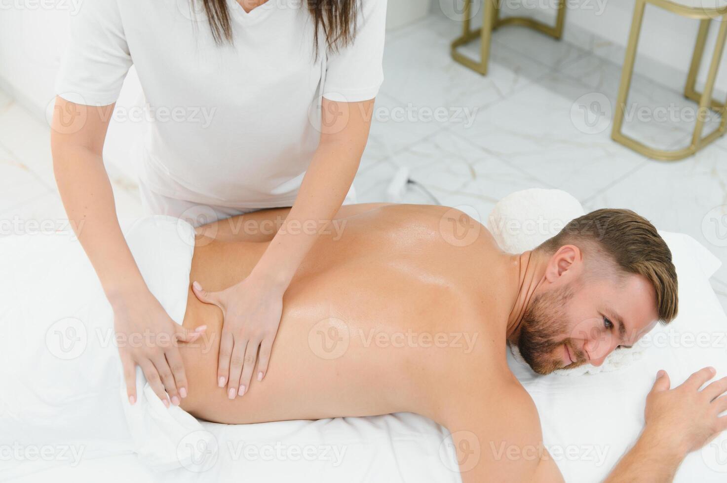 Handsome man receiving massage at spa photo