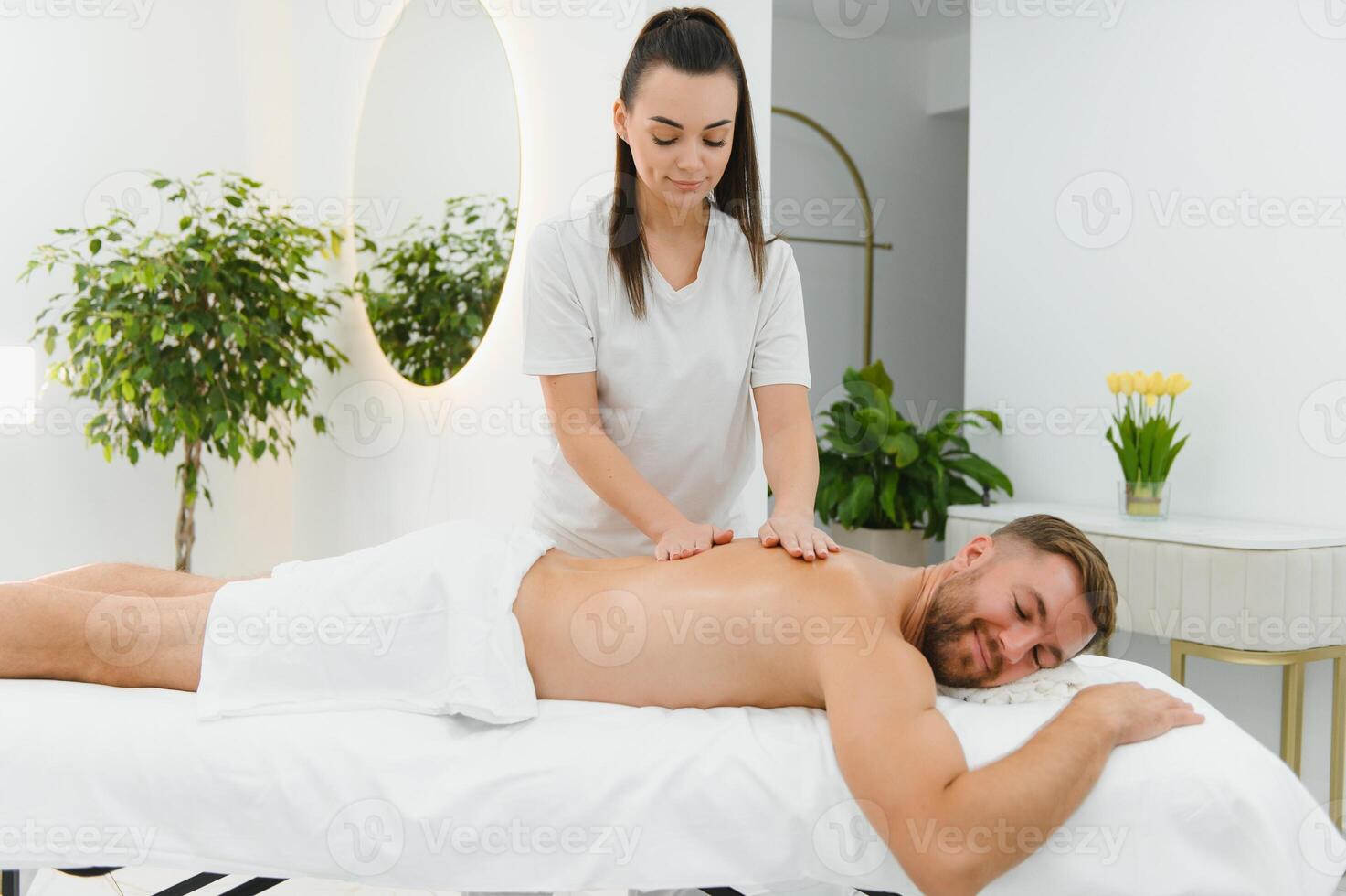 Young man is enjoying massage on spa treatment photo