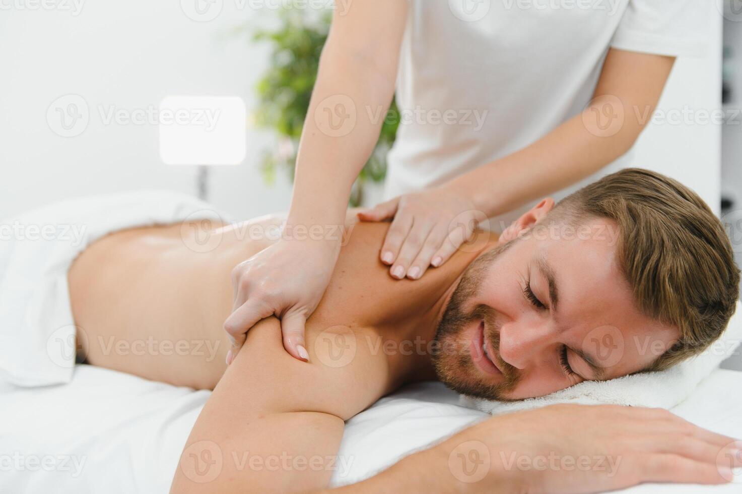 Handsome middle-aged man enjoying relaxing spa massage with oils photo