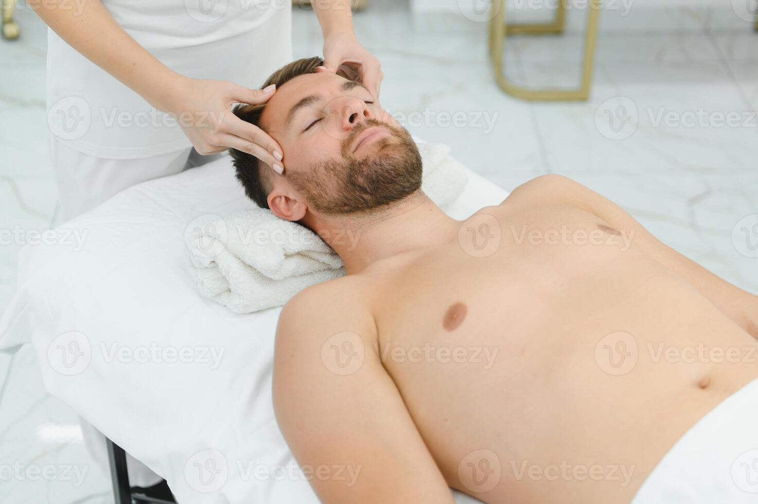 Handsome middle-aged man enjoying relaxing spa massage with oils photo