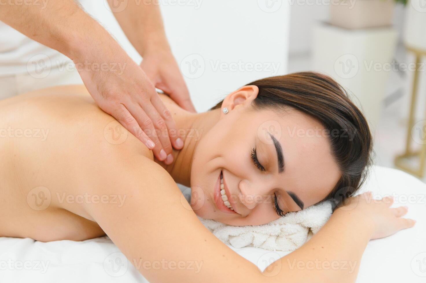 Spa therapy. Beautiful young woman lying on table during massage in salon, closeup photo