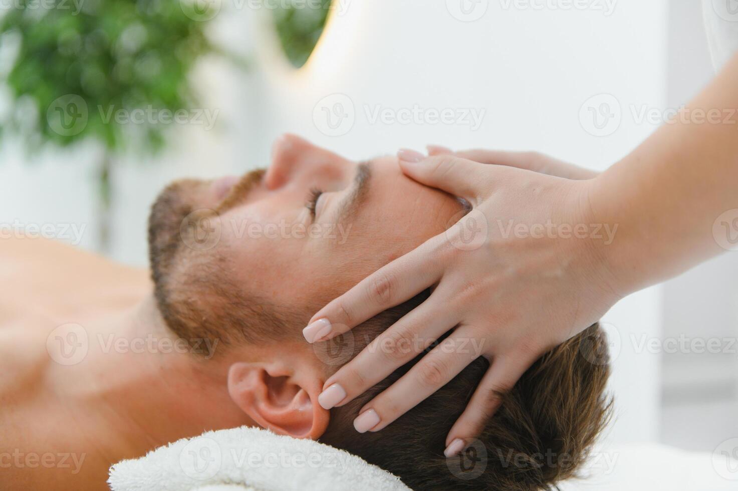 Handsome middle-aged man enjoying relaxing spa massage with oils photo