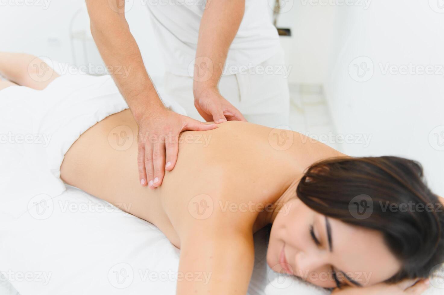 Young woman getting back massage in spa salon photo