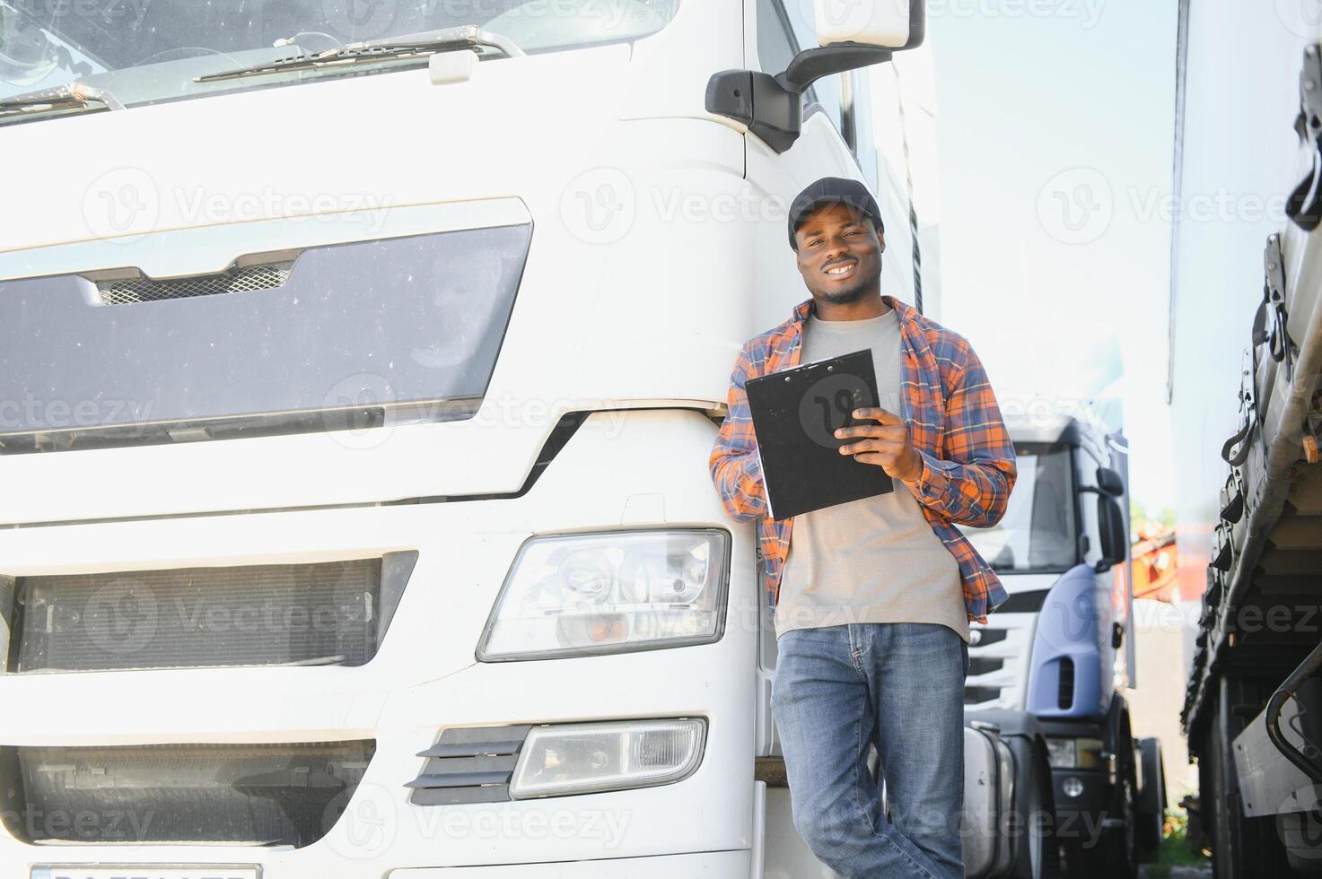African American truck dispatcher inspecting a vehicle on a parking lot photo