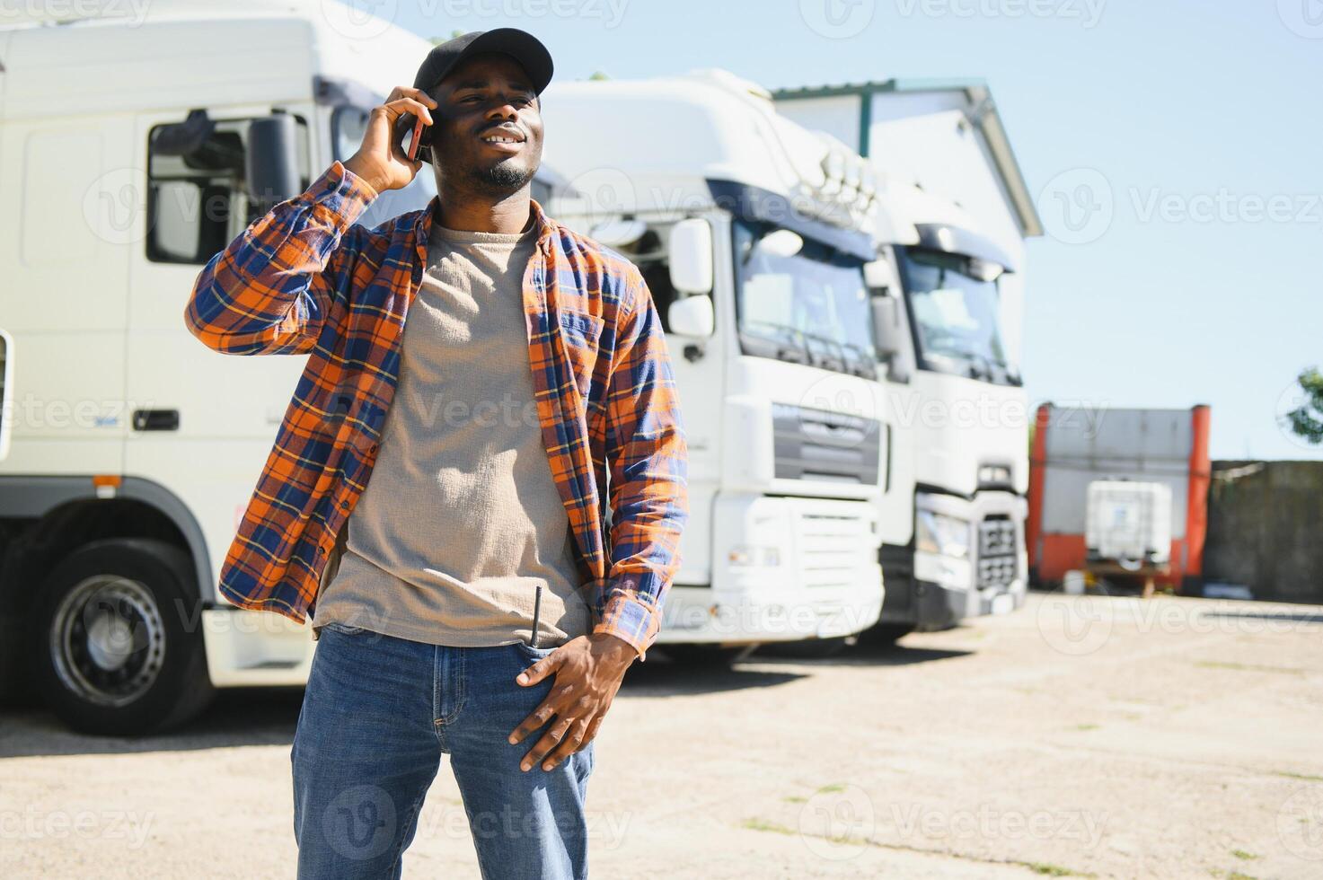 Professional truck driver holding smart phone in front of the trucks photo