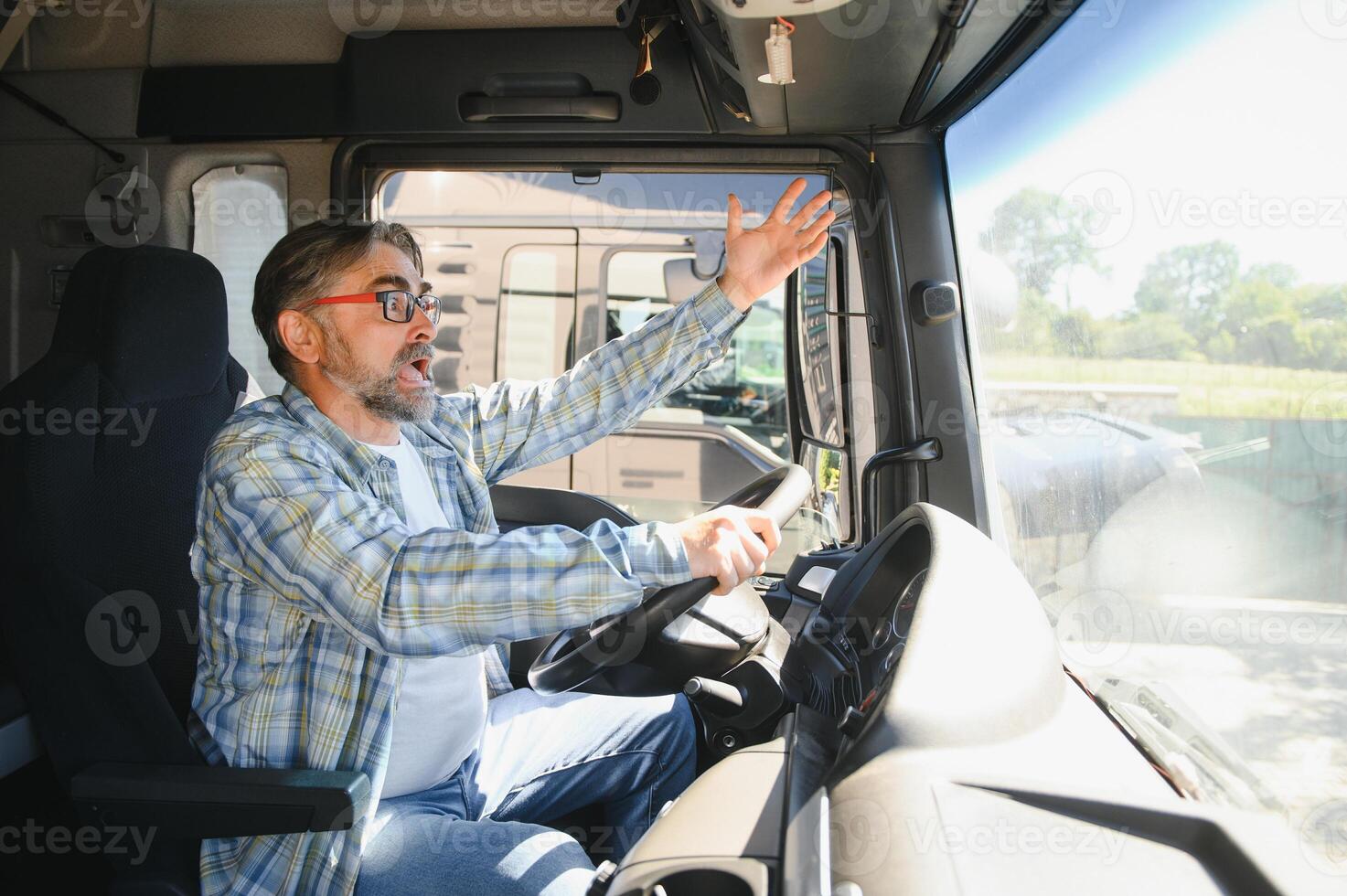 Shot of mad and nervous professional truck driver having arguing in traffic and yelling at someone. Transportation traffic problems photo