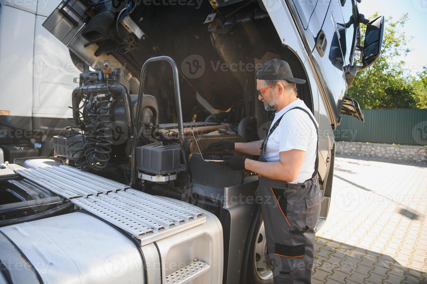Experienced auto repair shop worker performing customer car computer diagnostics photo