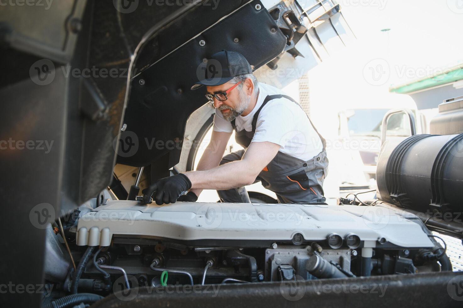 A senior worker checks wheel. Truck malfunction. Service work photo