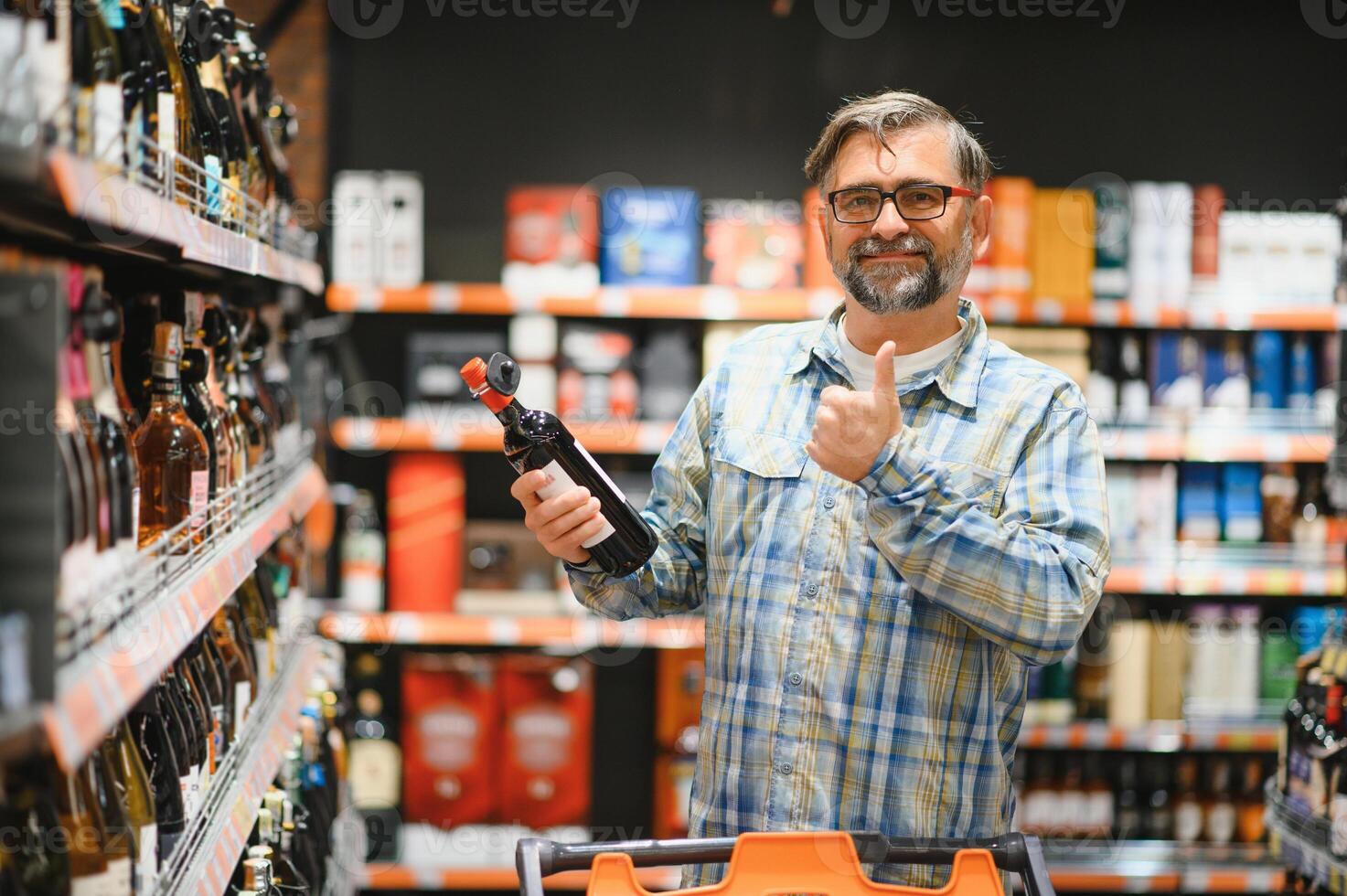 A man takes alcoholic drinks from the supermarket shelf. Shopping for alcohol in the store photo
