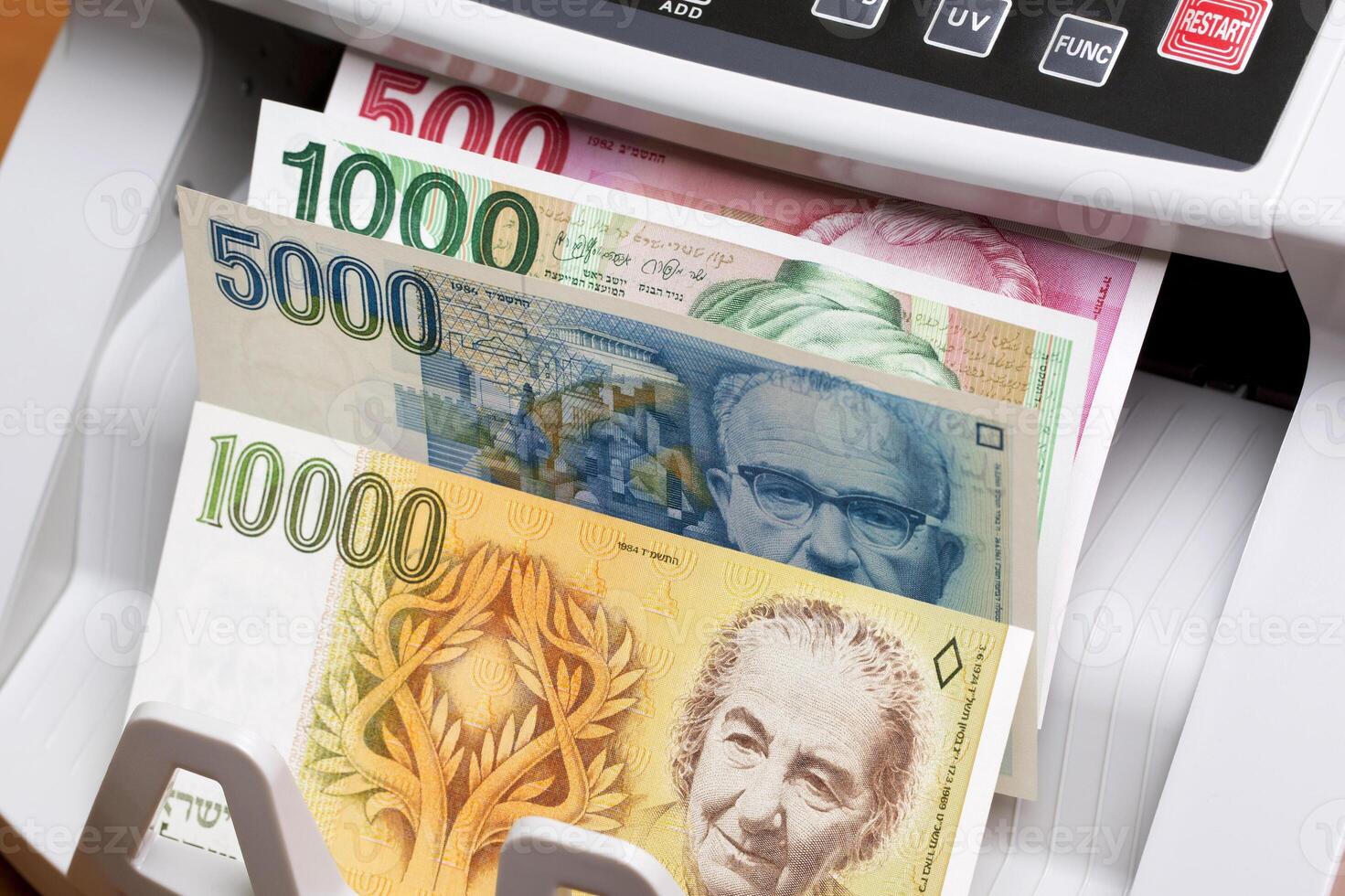 Israeli new shekel in the counting machine photo