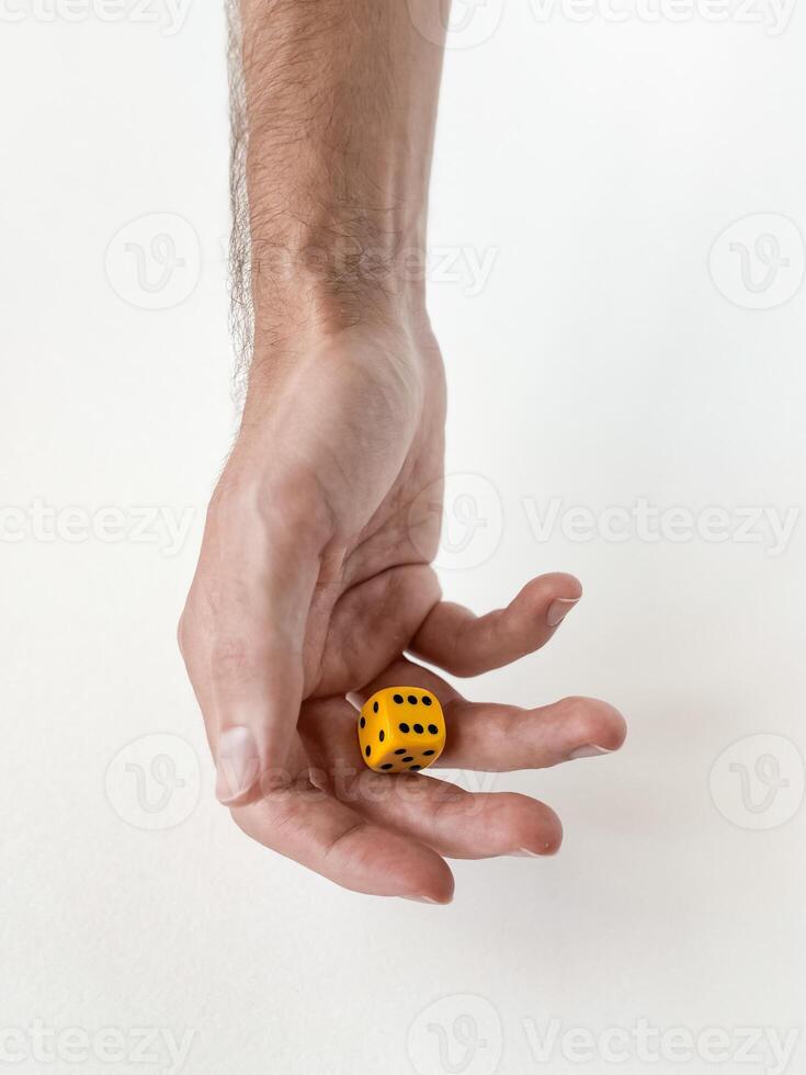 Hand holding yellow die. minimalist concept of chance and decision-making photo