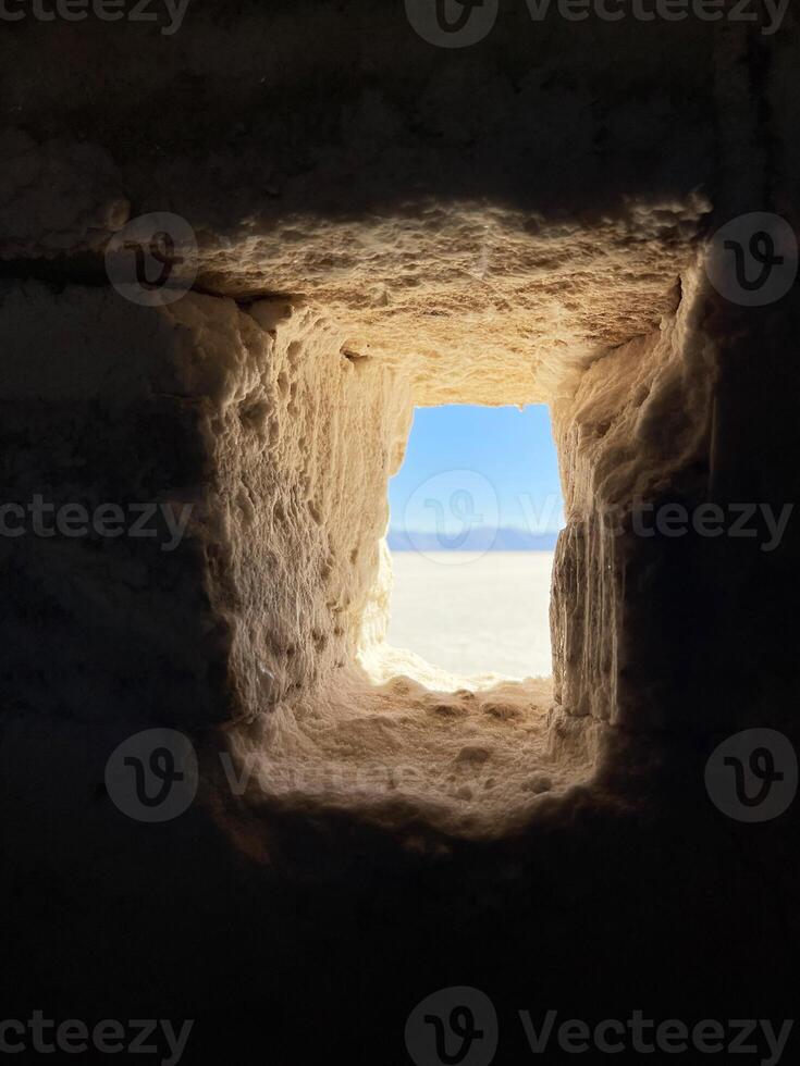 View of the salt marsh through the window of a house made of salt blocks. Salinas Grandes, Argentina photo