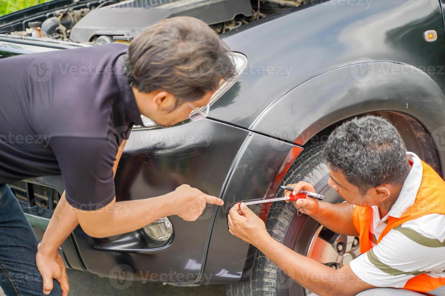 A car mechanic measures the length of the front bumper's wound according to the vehicle's entry point to wait for repair photo