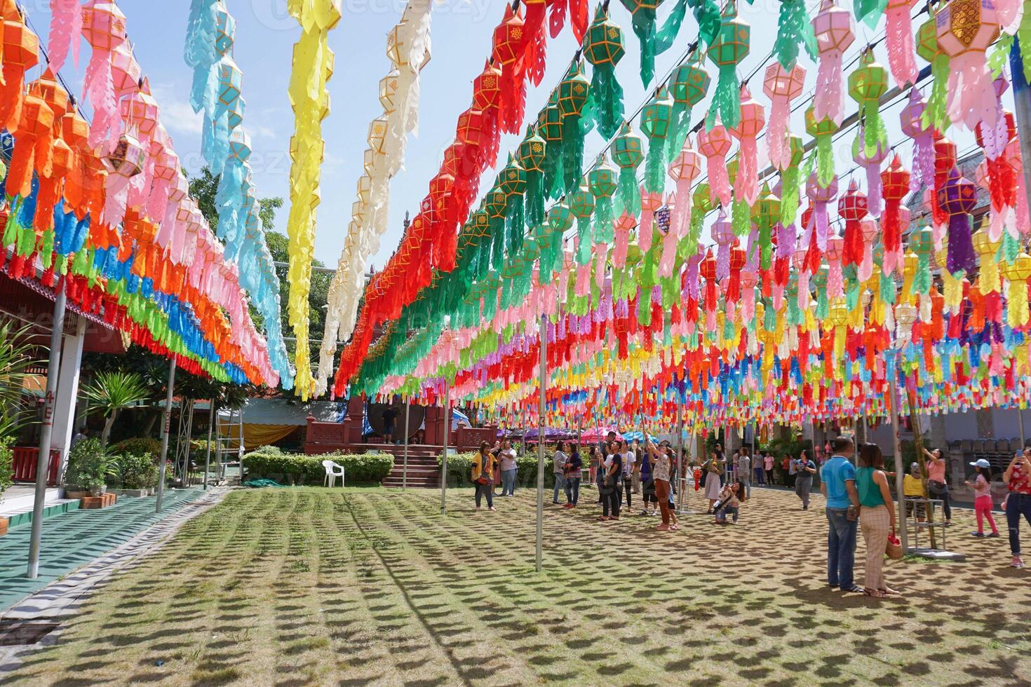 Lumphun city, TH 2019 - Colorful perspective view of Thai Lanna style lanterns to hang in front of the temple with people and tourists in hundred thousand lanterns festival. photo