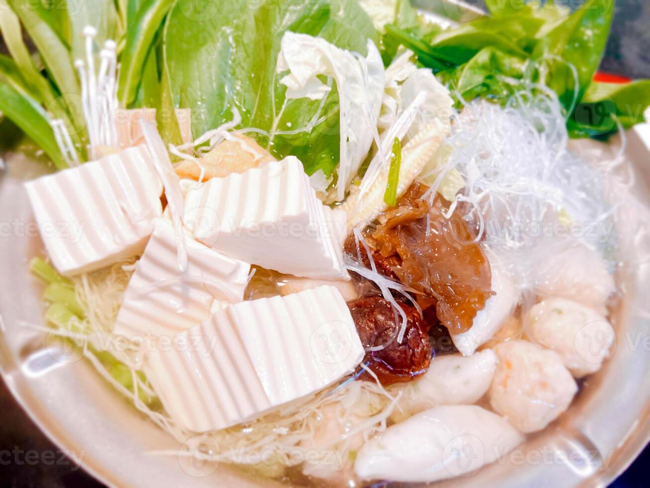 Closeup and crop Japanese hot pot Sukiyaki dinner set with Vegetables, tofu and fish balls in iron pot. photo