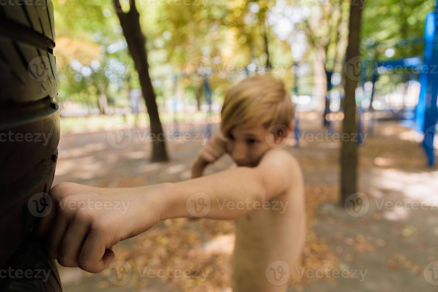 A close-up of the boy's fist practicing self-defense. Athletic teenage boy in the park outdoor workout session photo