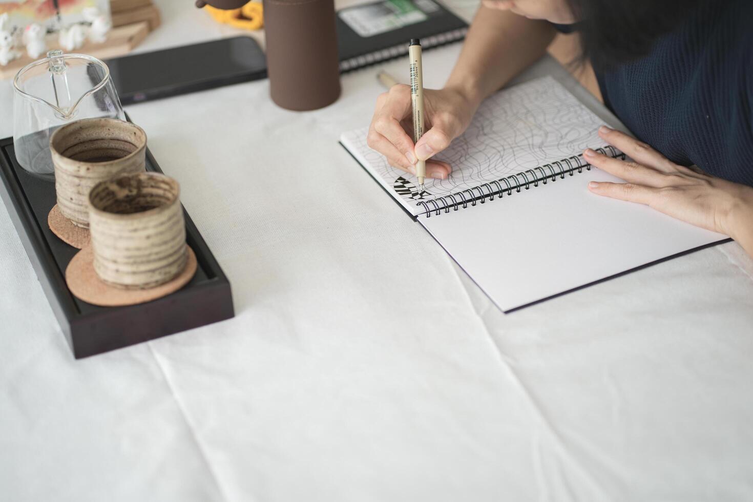 Top of hand drawing down on her notebook , work space concept. photo