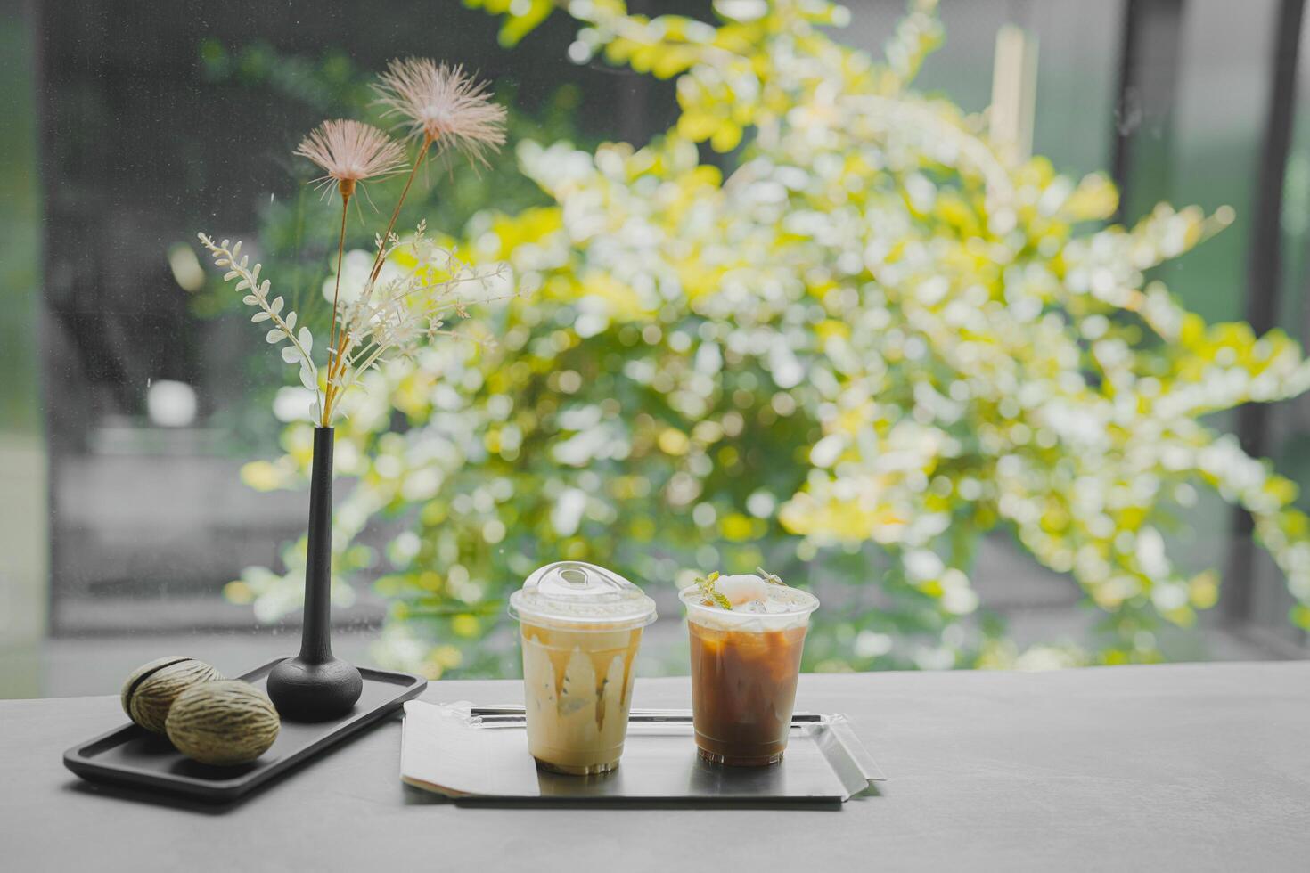 Close up glass of ice black coffee with lychee juice and ice cappucino on raw cement table of a coffee shop summer terrace, menu photography. photo