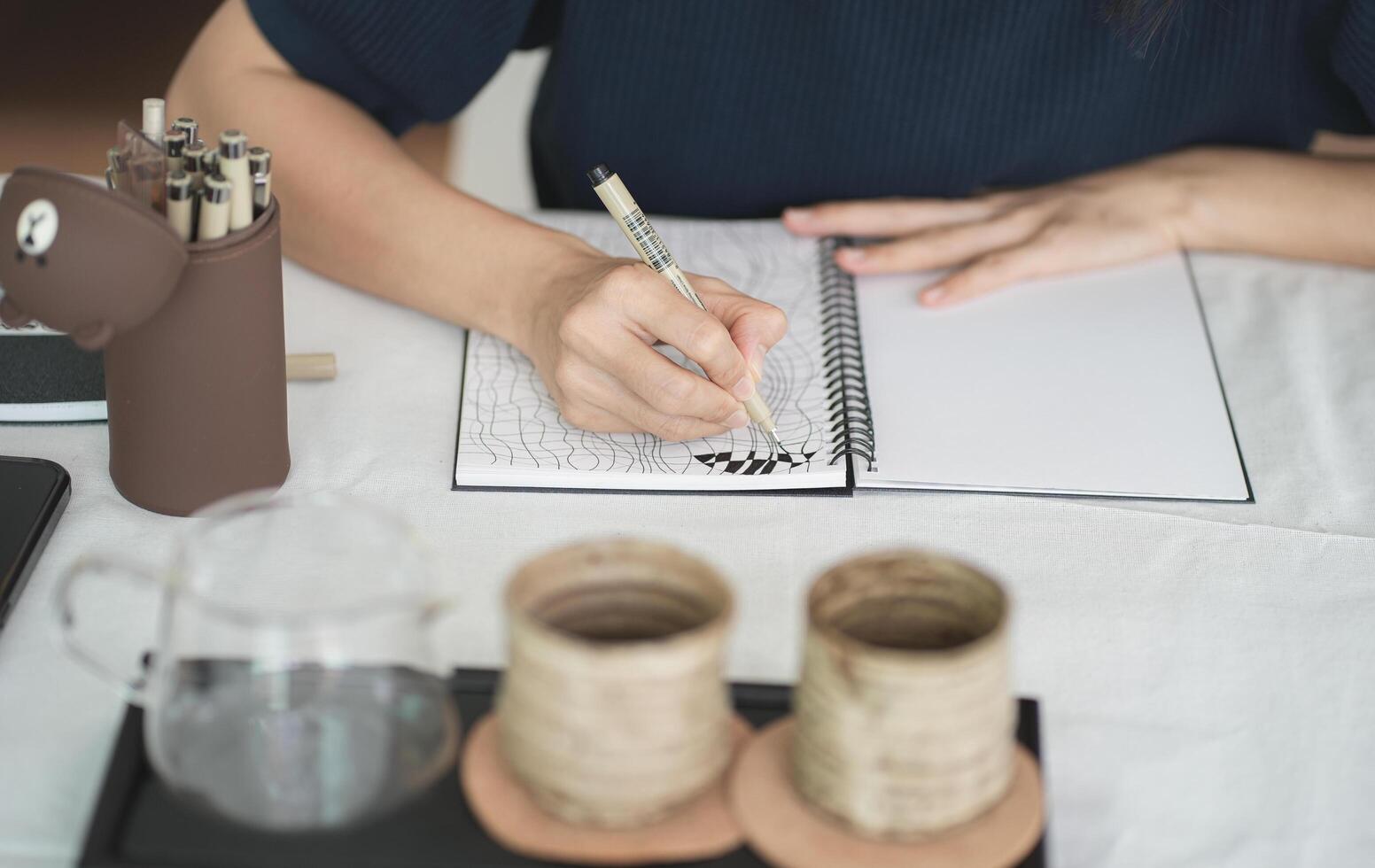Top of hand drawing down on her notebook , work space concept. photo