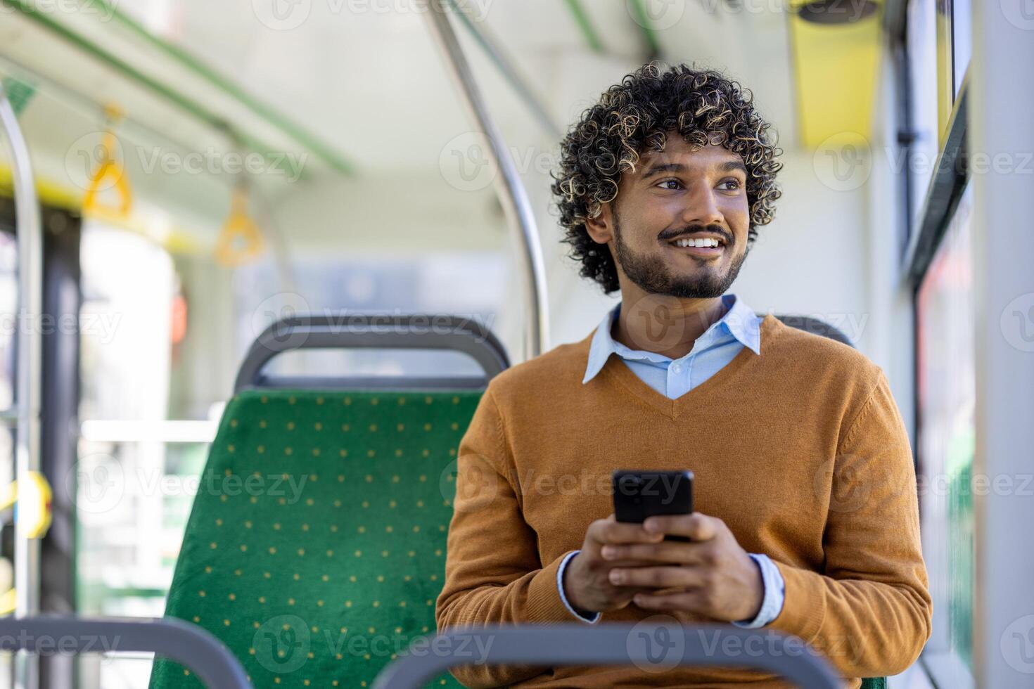 Smiling man sitting on bus seat using smartphone during commute. Relaxed expression capturing moment of joy and connectivity. Concept of travel, technology, public transportation. photo
