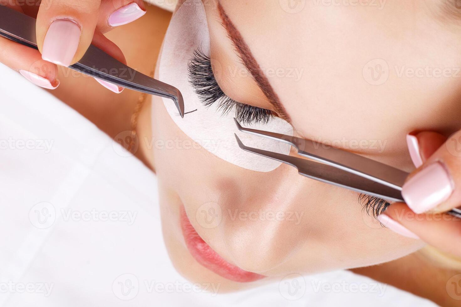 Eyelash Extension Procedure. Woman Eye with Long Eyelashes. Lashes, close up, macro, selective focus. photo