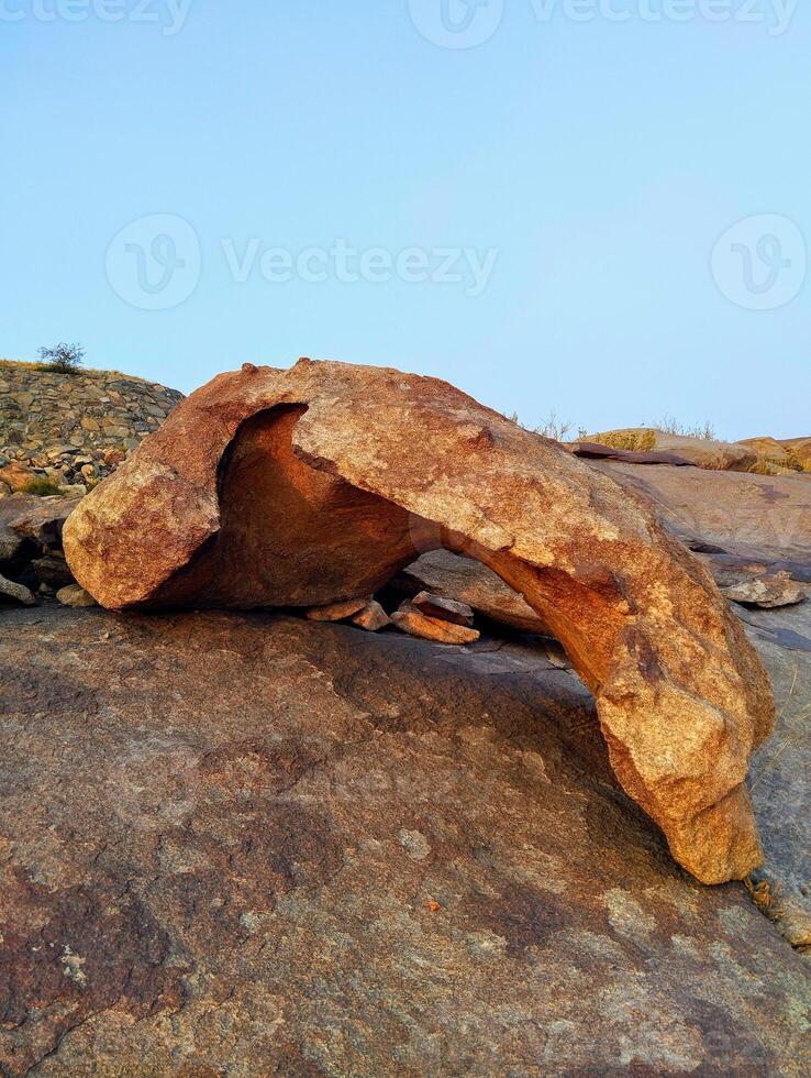 A rock that is sitting on top of a hill photo