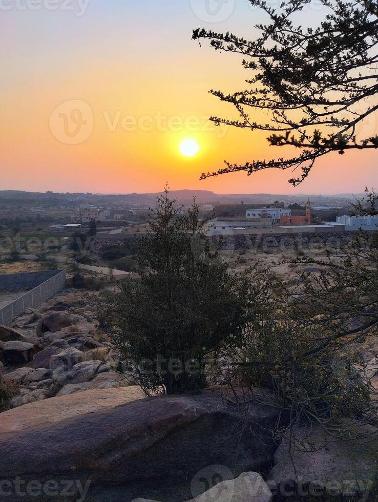 the sun sets over the desert in the middle of the day photo