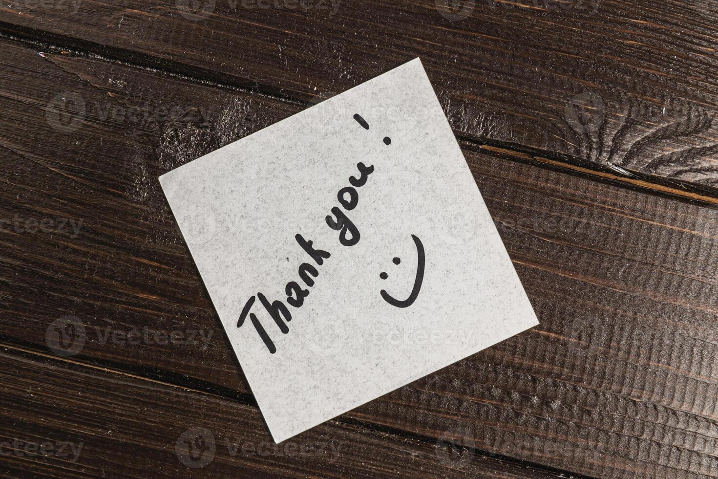 White thank you note on wooden table photo