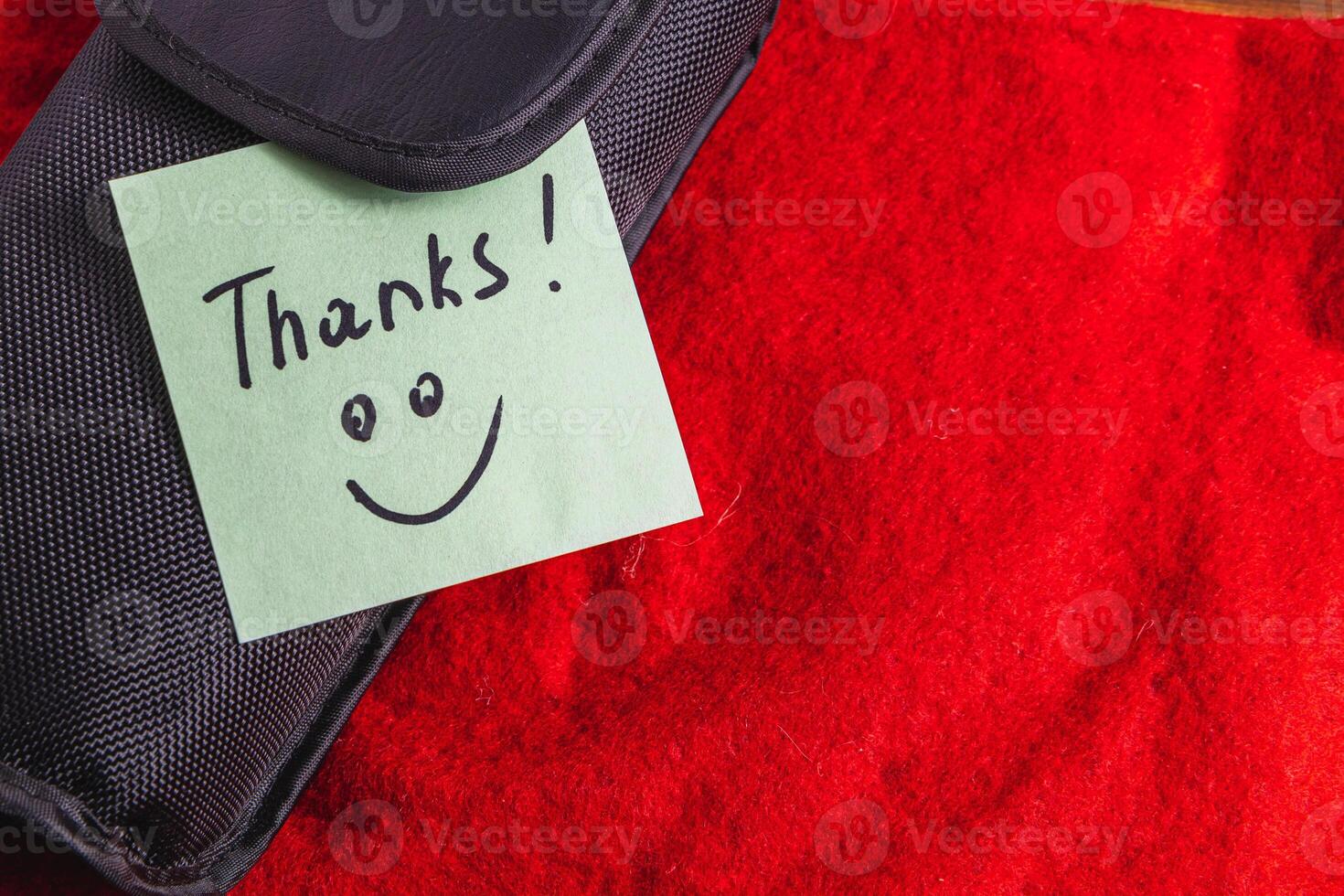A soft black box on a red background with a turquoise thank you label photo