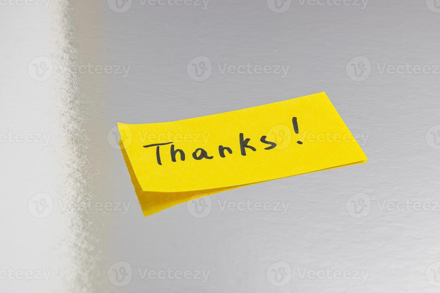 A small note with the word thank you on a silver background photo