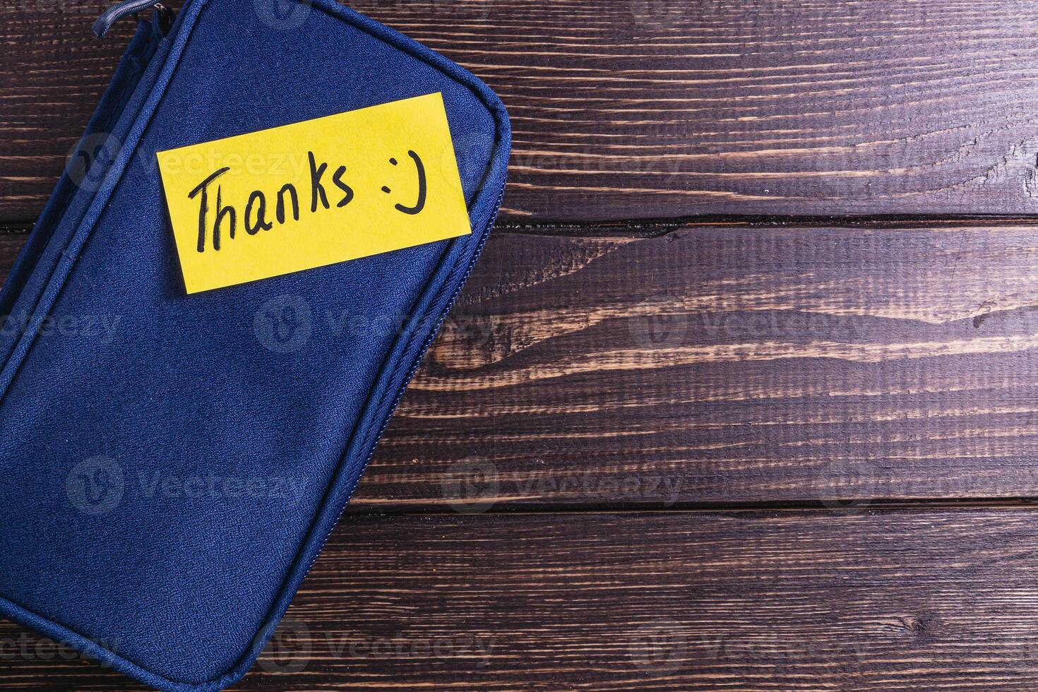 A note with the word thank you on a blue soft box on the table photo