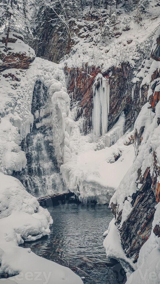 Huk waterfall, frozen waterfall at winter, Carpathian National Park. Ukraine. photo