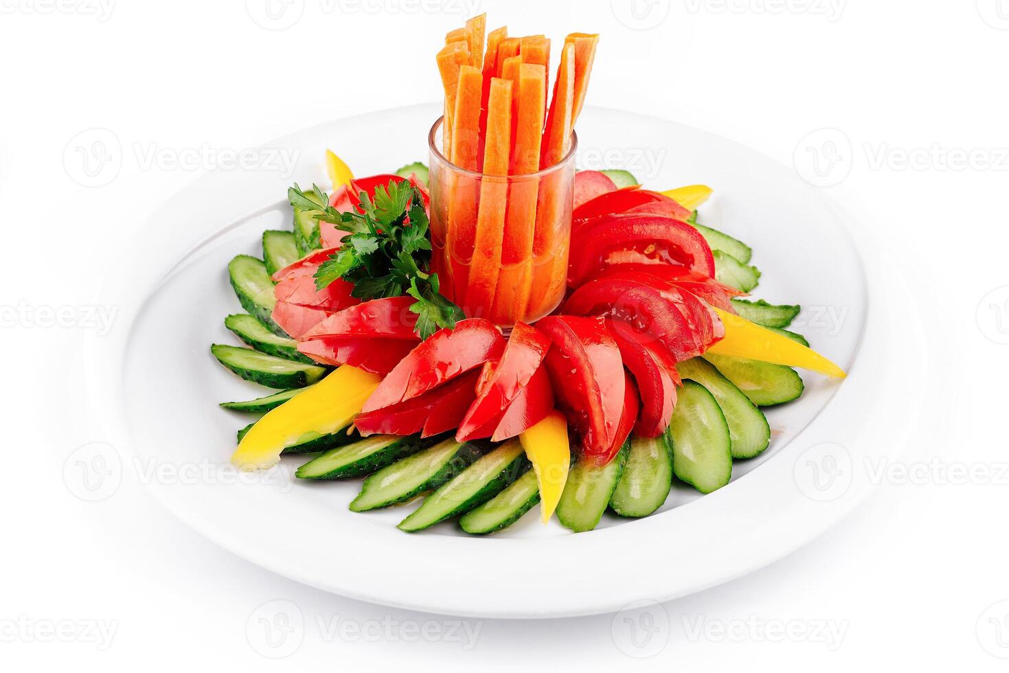 Fresh vegetables arranged on plate forming flower shape with carrots in the middle photo