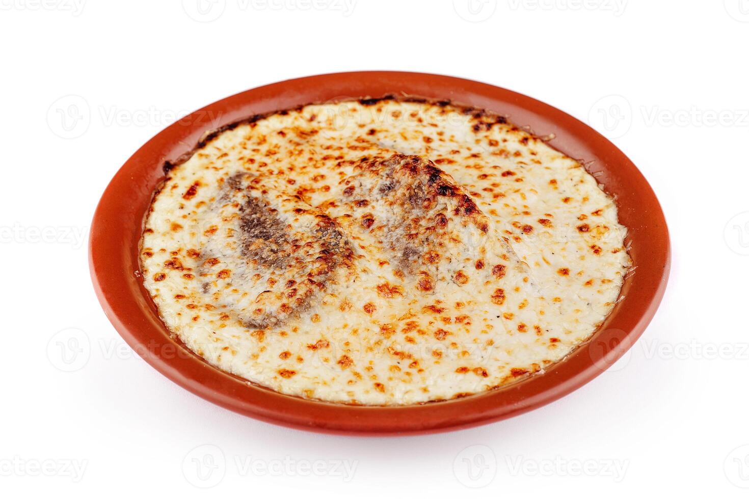 Delicious lasagna with meat and cheese baking in rustic clay plate photo